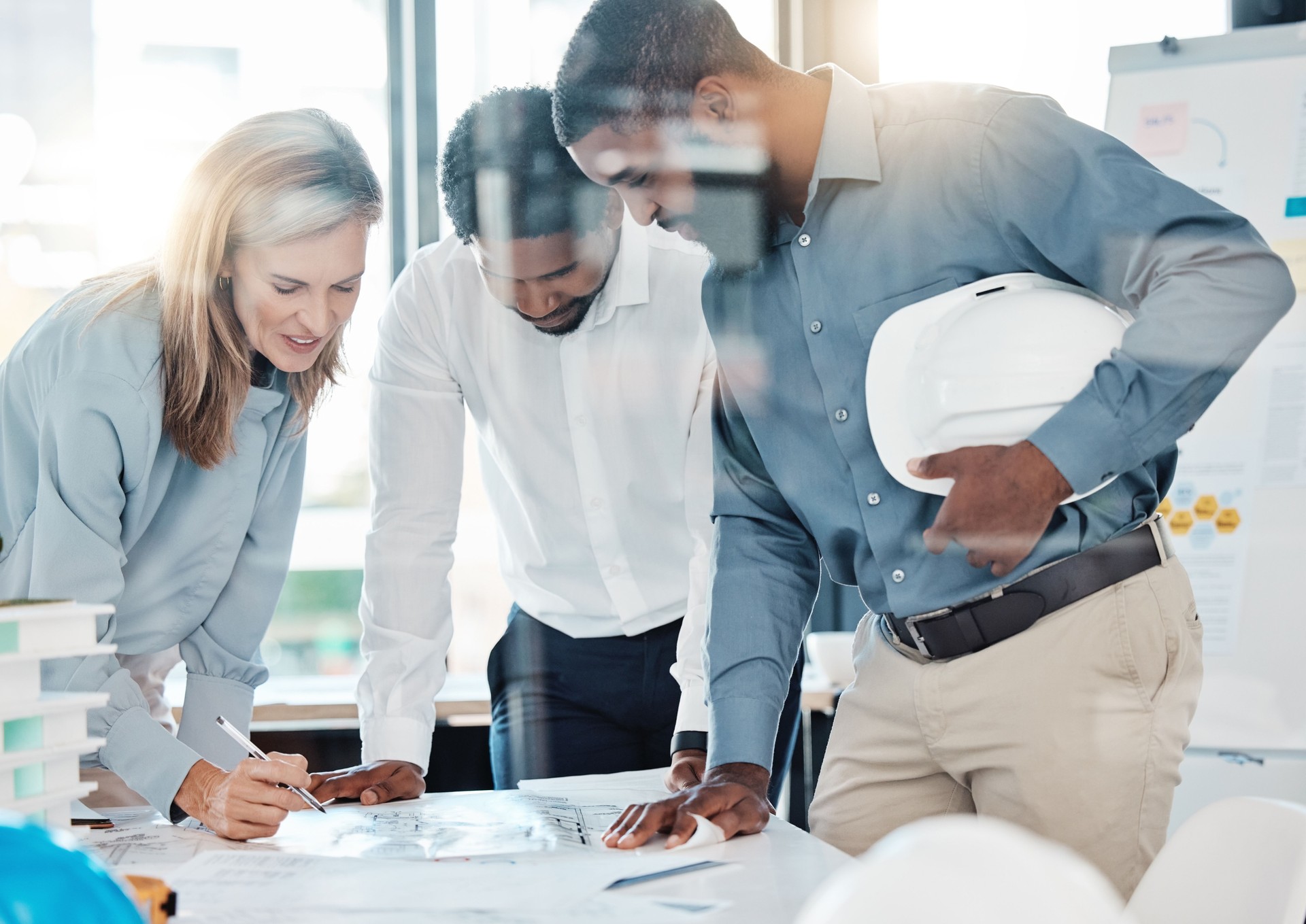 Collaboration, meeting and design with architect in office with blueprint, planning and project management. Engineering, teamwork and architecture with professional designer employees